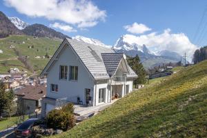 uma casa branca numa colina com montanhas ao fundo em New Chalet with breathtaking views! em Alt Sankt Johann