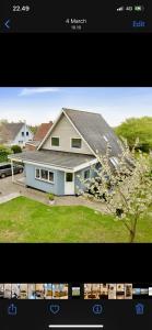 a picture of a house with a tree in the yard at Big villa in stege near møns klint with trampolin in Stege
