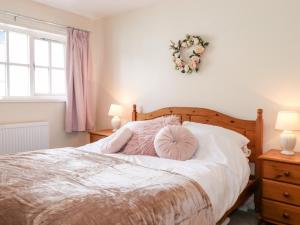 a bedroom with a bed with a heart pillow on it at Swallows Nest Cottage in Ambleside