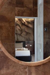 Palazzo Ferrucci Luxury Suites في كالياري: غرفة نوم مع سرير في مرآة