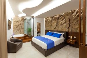 1 dormitorio con 1 cama extragrande y baño en Palazzo Ferrucci Luxury Suites, en Cagliari