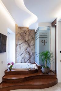 a bathroom with a tub and a potted plant at Palazzo Ferrucci Luxury Suites in Cagliari