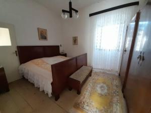 a bedroom with a bed and a window at Apartments Kaštel in Ložišće