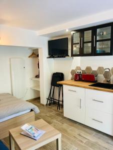 a room with a bed and a kitchen with white cabinets at Appart'Hotel au Pradet in Le Pradet