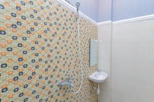 a bathroom with a shower with a sink and a toilet at Urbanview Hotel Syariah Near Gelora Delta Sidoarjo in Sidoarjo