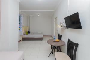 a small living room with a table and a television at Urbanview Hotel Syariah Near Gelora Delta Sidoarjo in Sidoarjo