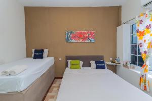 a bedroom with two beds and a window at Urbanview Hotel Syariah Near Gelora Delta Sidoarjo in Sidoarjo