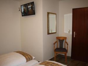 レンネシュタットにあるFEWO Bilsteinのベッドルーム1室(ベッド1台、椅子、鏡付)