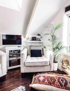 a living room with a couch and a tv at The Old Stores, Luxury beach side selfcatered holiday cottage above the beach in Porthleven