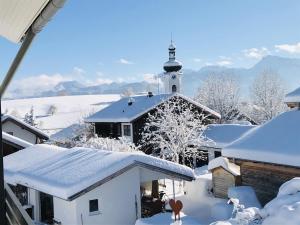 a church with a snow covered roof with a lighthouse at Ferienwohnung Vivien in Rieden