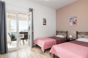 a bedroom with two beds and a balcony at Katerina Horizon Apartments by Konnect - 1,8km from Ipsos beach in Ipsos