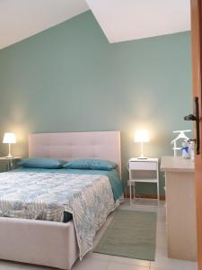 een slaapkamer met een groot bed en 2 lampen bij Casetta Donatello in Marina di Pietrasanta