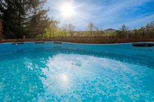 uma grande piscina azul com o sol ao fundo em Weinquartier Kalter Hügel em Naumburg