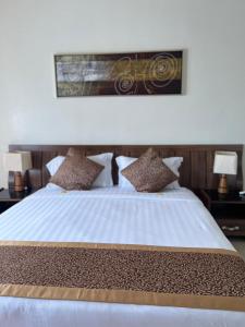 a bedroom with a large white bed with pillows at المواسم الاربعة للاجنحه الفندقية in Al Jubail