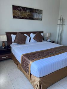 a bedroom with a large bed with white sheets and pillows at المواسم الاربعة للاجنحه الفندقية in Al Jubail