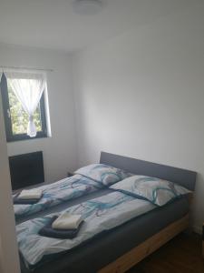 Bett in einem Schlafzimmer mit Fenster in der Unterkunft Terec Haus in Bruckneudorf