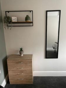 a mirror and a dresser in a room at Cedar House by ShortStays4U A modern 2 bedroom house with free parking in town centre! in King's Lynn
