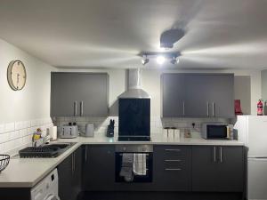 a kitchen with black and white appliances and a ceiling at Cedar House by ShortStays4U A modern 2 bedroom house with free parking in town centre! in King's Lynn +3 photos