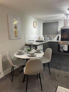 a kitchen with a table and chairs in a room at Cedar House - 2 bedroom house with free parking by ShortStays4U in King's Lynn