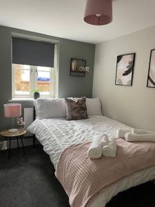 1 dormitorio con 1 cama con toallas en Cedar House - 2 bedroom house with free parking by ShortStays4U en Kings Lynn