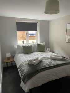 a bedroom with a bed with two towels on it at Cedar House - 2 bedroom house with free parking by ShortStays4U in King's Lynn