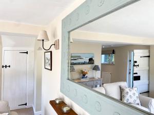 a living room with a mirror on the wall at Keepers Cottage in Petersfield