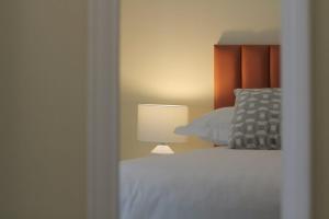 a bedroom with a white bed and a lamp at Burrow Park Holiday Apartments in Rosslare