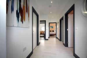 a hallway with doors and paintings on the walls at Burrow Park Holiday Apartments in Rosslare