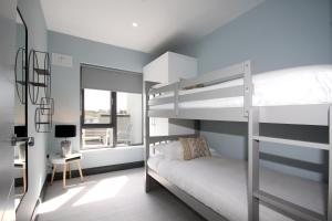 a bedroom with two bunk beds and a desk at Burrow Park Holiday Apartments in Rosslare