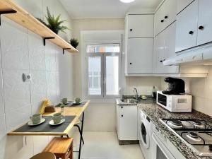 a kitchen with white cabinets and a counter top at Green Door Coruña in A Coruña