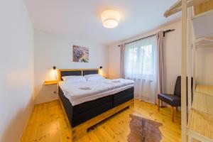 ein Schlafzimmer mit einem großen Bett und einem Fenster in der Unterkunft Apartmány Lipno 46 in Lipno nad Vltavou