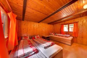 een slaapkamer met 2 bedden in een houten hut bij Autokemping Jasov in Jazo