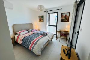ein Schlafzimmer mit einem Bett und einem Tisch mit einer Lampe in der Unterkunft Villa Marie 1 - Superbe appartement climatisé 2 chambres Vue Mer in Le Grau-du-Roi
