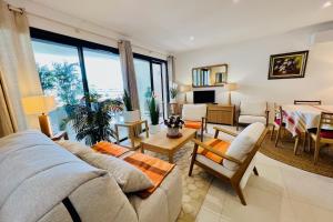 ein Wohnzimmer mit Sofa und Tisch in der Unterkunft Villa Marie 1 - Superbe appartement climatisé 2 chambres Vue Mer in Le Grau-du-Roi