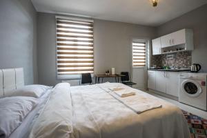 1 dormitorio con 1 cama blanca grande y cocina en Zelya İstanbul flats, en Estambul