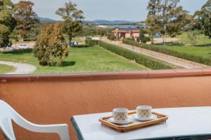 two coffee cups on a tray on a table on a balcony at Casa Rosella by Wonderful Italy in Olbia