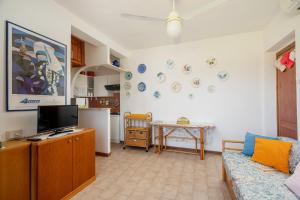 a living room with a couch and a tv and a table at Casa Rosella by Wonderful Italy in Olbia