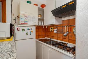 a kitchen with a white refrigerator and a sink at Casa Rosella by Wonderful Italy in Olbia +6 photos