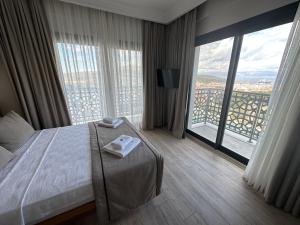 a hotel room with a bed and a large window at Nova Butik Hotel Çeşme in Cesme