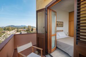 a bedroom with a bed and a balcony with a view at Casa Rosella by Wonderful Italy in Olbia