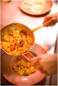 a person is cooking food in a pan at RTA Costa Etrusca in San Vincenzo