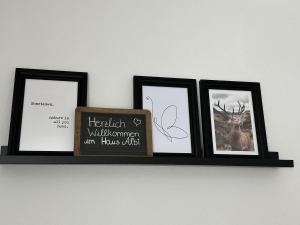 un estante con tres fotos y un cartel en él en Haus Albi, en Waldkirch