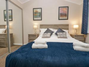 a bedroom with a large bed with blue sheets and pillows at 8 Woodlands in Ulverston
