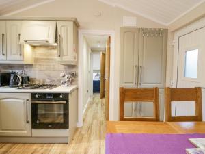 a kitchen with white cabinets and a stove top oven at 8 Woodlands in Ulverston