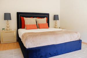 um quarto com uma cama grande e almofadas laranja em Fish Village Terrace Luxo em Vila Nova de Gaia
