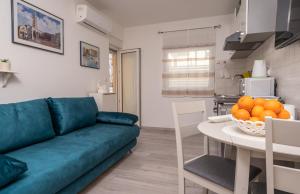 sala de estar con sofá y mesa con naranjas. en Apartment Fiorella en Pula