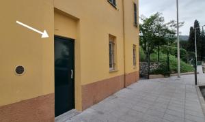 een geel gebouw met een deur met een pijl erop bij Studio de charme climatisé Gare Riquier in Nice