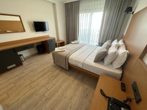 una camera d'albergo con letto e TV di Nova Butik Hotel Çeşme a Çeşme