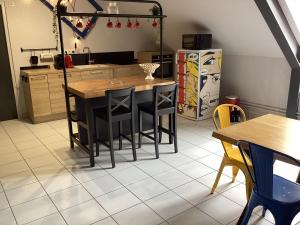 La cuisine est équipée d'une table, de chaises et d'un réfrigérateur. dans l'établissement L’INSOLITE, à Pierry