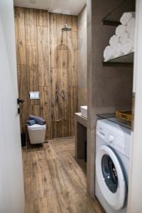 a bathroom with a shower and a washing machine at Pebble Garden Orchid in Kos Town